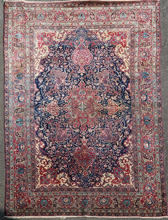 A Persian red and blue ground carpet. 9ft 10in by 7ft 2in.